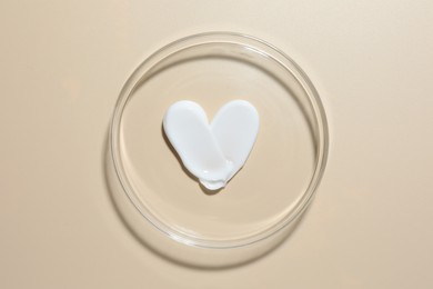 Photo of Cosmetic product in Petri dish on beige background, top view