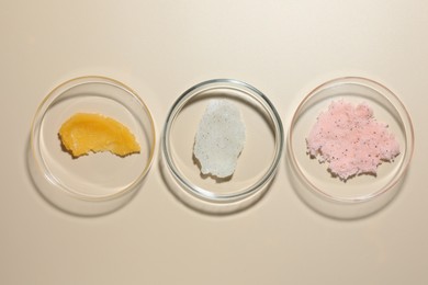 Photo of Different cosmetic products in Petri dishes on beige background, flat lay