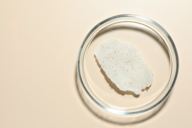 Photo of Cosmetic product in Petri dish on beige background, top view. Space for text