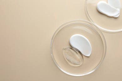 Photo of Different cosmetic products in Petri dishes on beige background, flat lay. Space for text