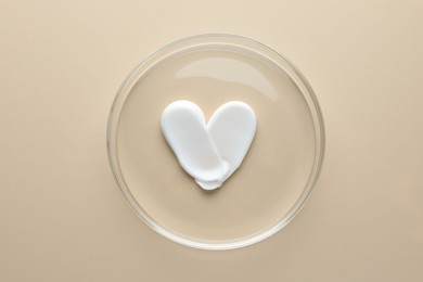 Photo of Cosmetic product in Petri dish on beige background, top view