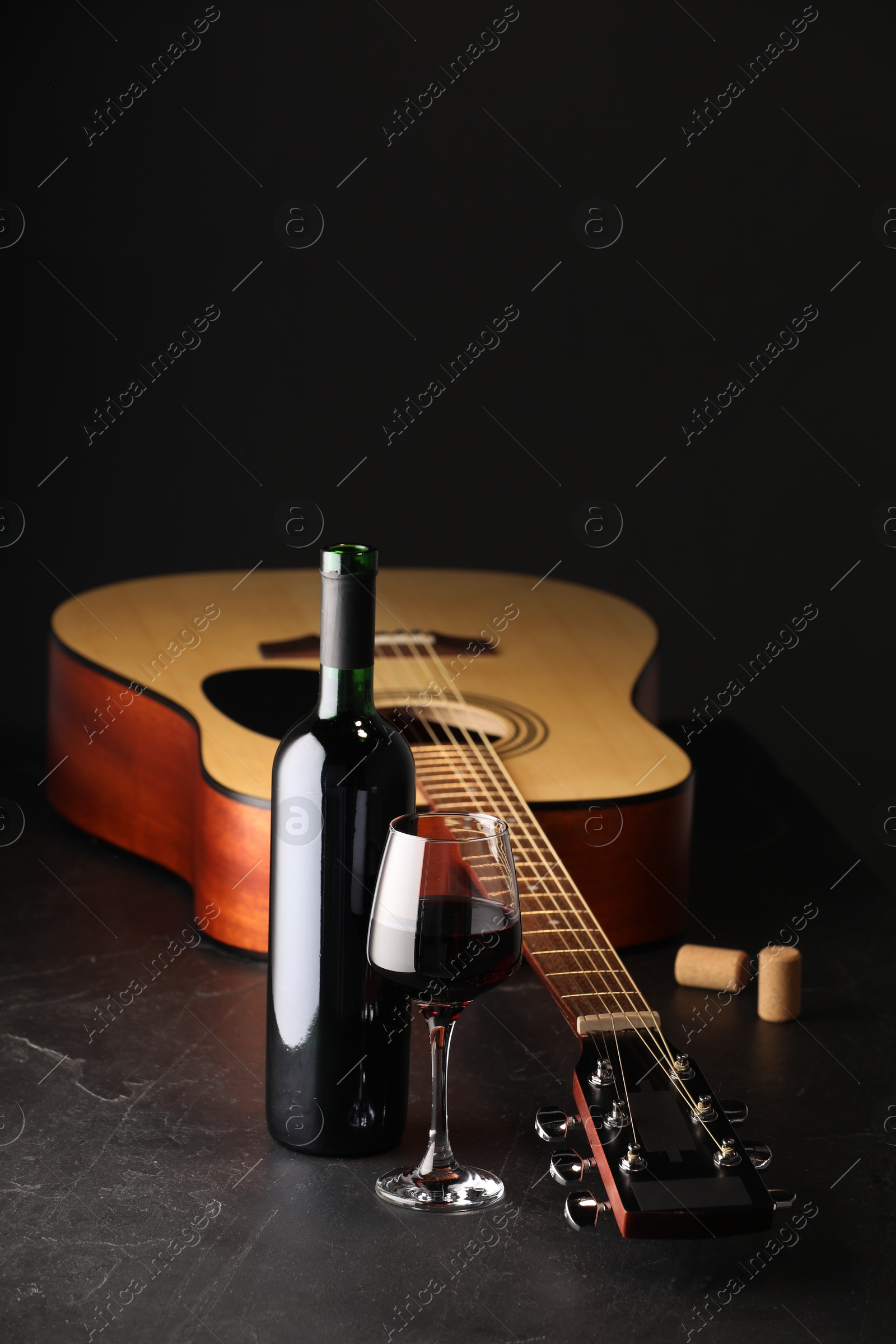 Acoustic guitar and red wine on black table, closeup. Space for text Photo of Acoustic guitar and red wine on black table, closeup. Space for text