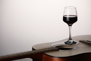 Photo of Acoustic guitar and red wine on white background, closeup. Space for text