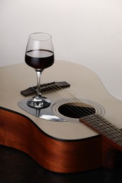 Photo of Acoustic guitar and red wine on white background, closeup