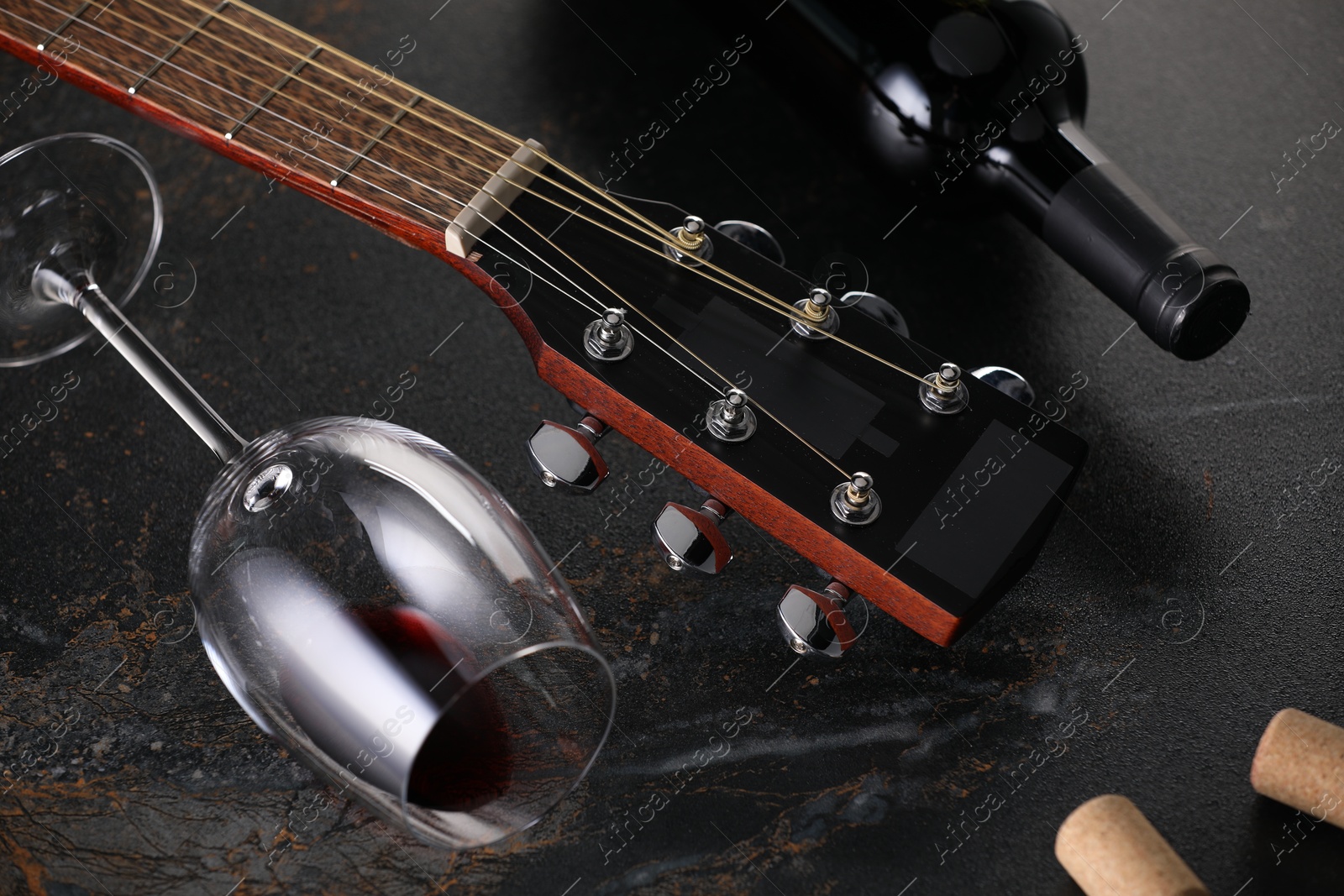 Acoustic guitar and red wine on black table, closeup Photo of Acoustic guitar and red wine on black table, closeup