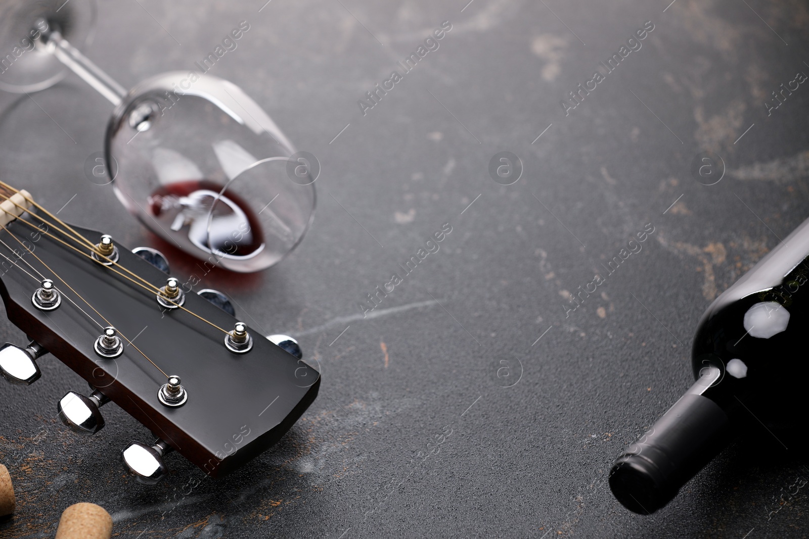Acoustic guitar and red wine on black table, closeup. Space for text Photo of Acoustic guitar and red wine on black table, closeup. Space for text