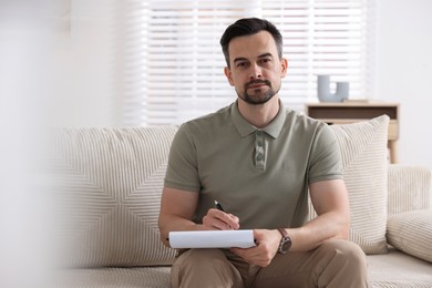 Photo of Professional psychologist with clipboard in his office. Space for text
