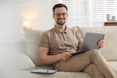Photo of Professional psychologist having online consultation with his client via laptop on sofa indoors