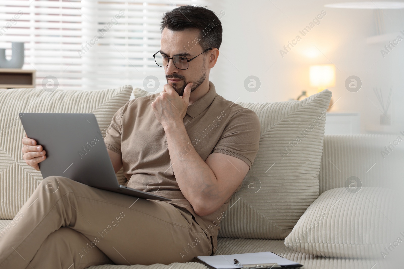 Professional psychologist having online consultation with his client via laptop on sofa indoors Photo of Professional psychologist having online consultation with his client via laptop on sofa indoors