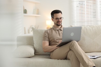 Photo of Professional psychologist having online consultation with his client via laptop on sofa indoors. Space for text
