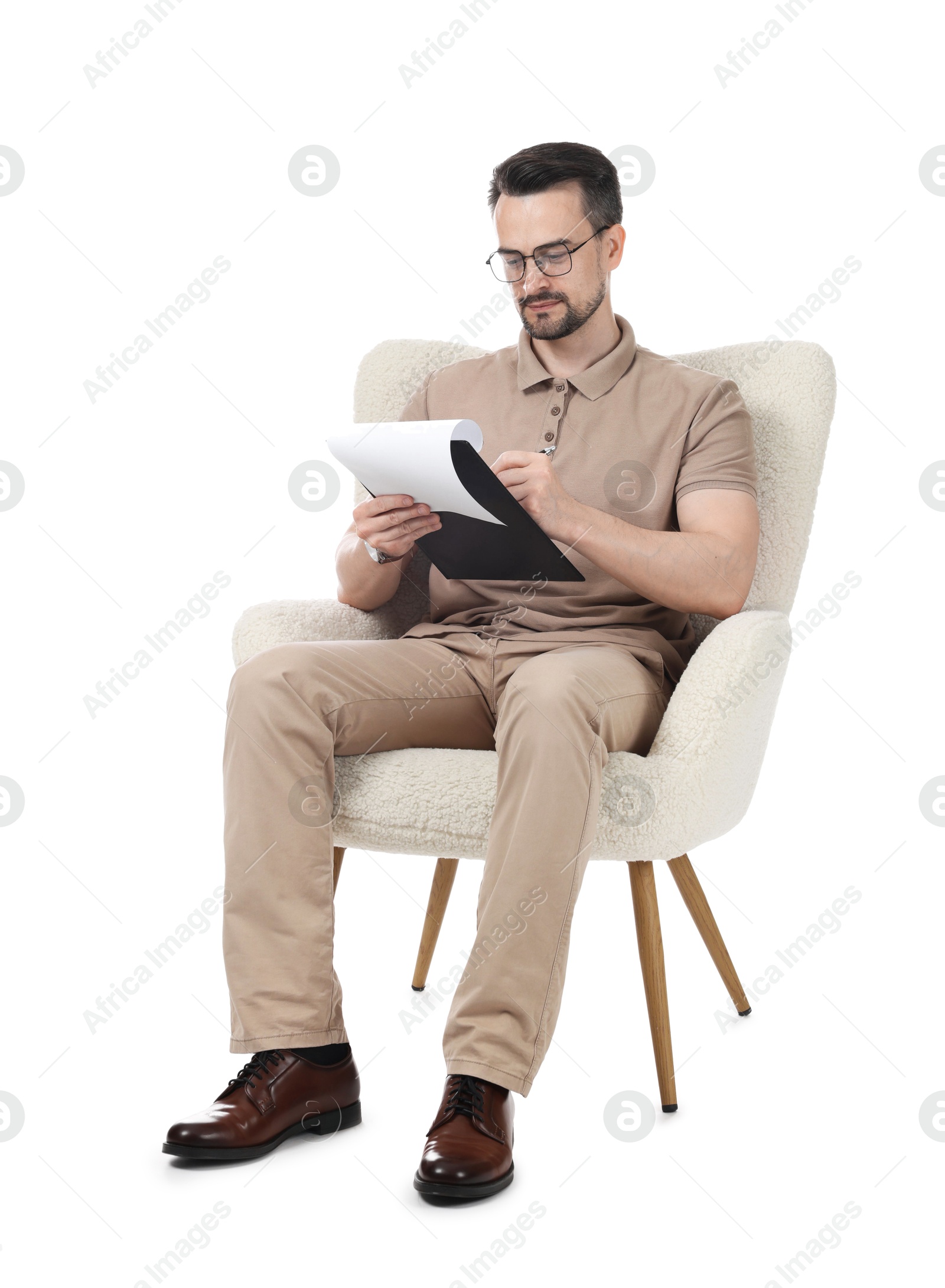 Professional psychologist with clipboard in armchair on white background Photo of Professional psychologist with clipboard in armchair on white background