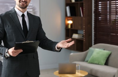Photo of Professional psychologist with clipboard inviting to his office, closeup. Space for text