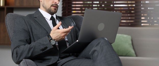 Photo of Professional psychologist having online consultation with his client via laptop indoors, closeup