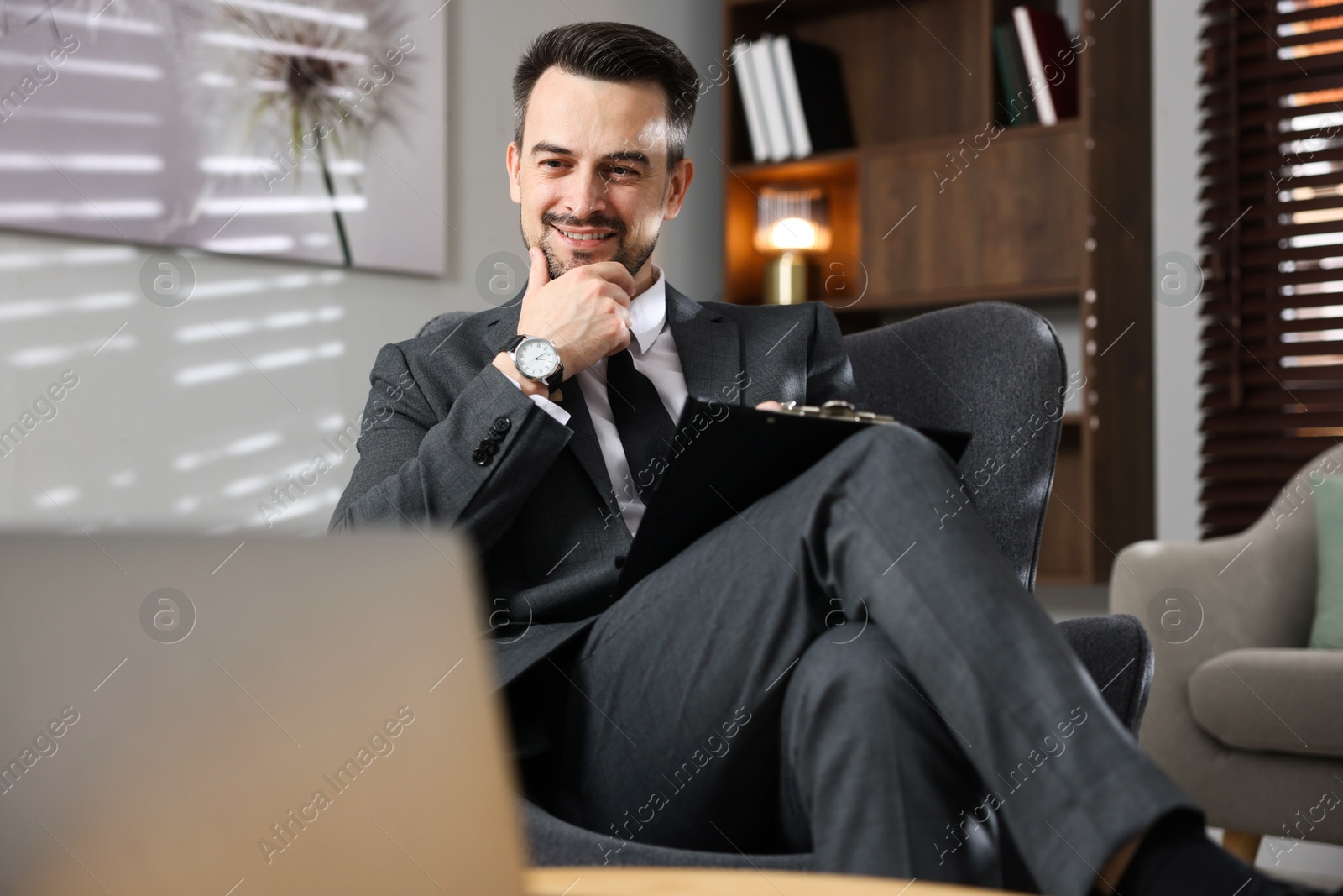 Photo of Professional psychologist having online consultation with his client via laptop indoors