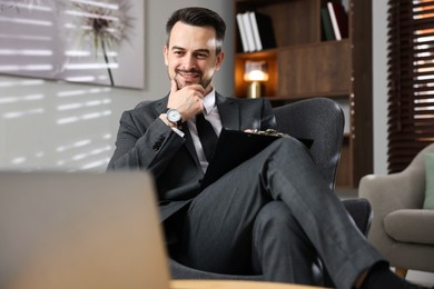 Photo of Professional psychologist having online consultation with his client via laptop indoors