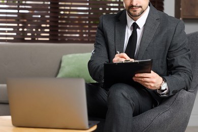 Photo of Professional psychologist having online consultation with his client via laptop indoors, closeup