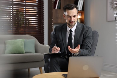 Photo of Professional psychologist having online consultation with his client via laptop indoors. Space for text
