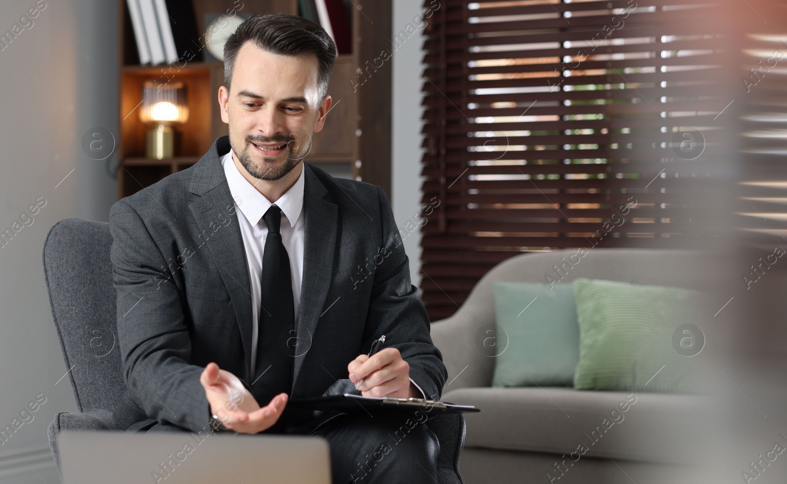 Photo of Professional psychologist with clipboard in his office. Space for text