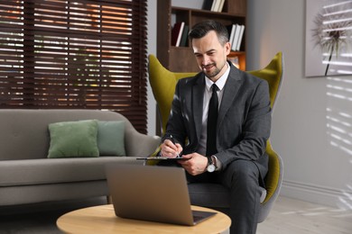 Photo of Professional psychologist having online consultation with his client via laptop indoors