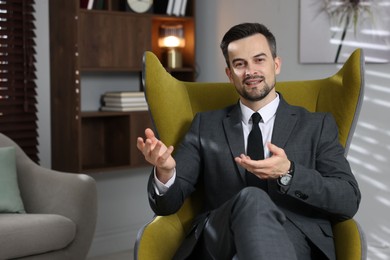 Photo of Professional psychologist in armchair at his office