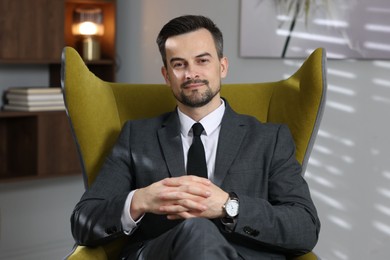Photo of Professional psychologist in armchair at his office