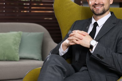 Photo of Professional psychologist in armchair indoors, closeup. Space for text