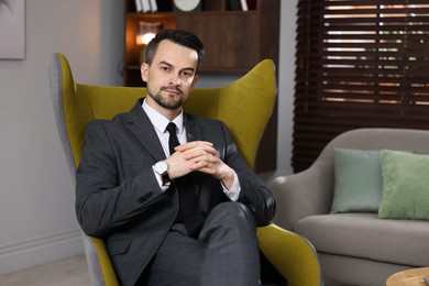 Photo of Professional psychologist in armchair at his office. Space for text