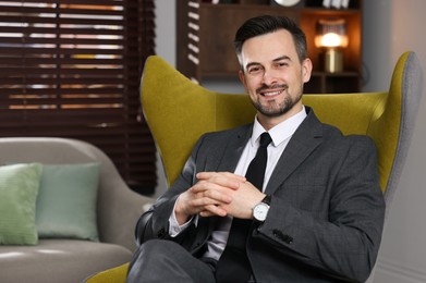 Photo of Professional psychologist in armchair at his office. Space for text