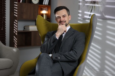 Photo of Professional psychologist in armchair at his office