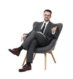 Photo of Professional psychologist with notebook in armchair on white background