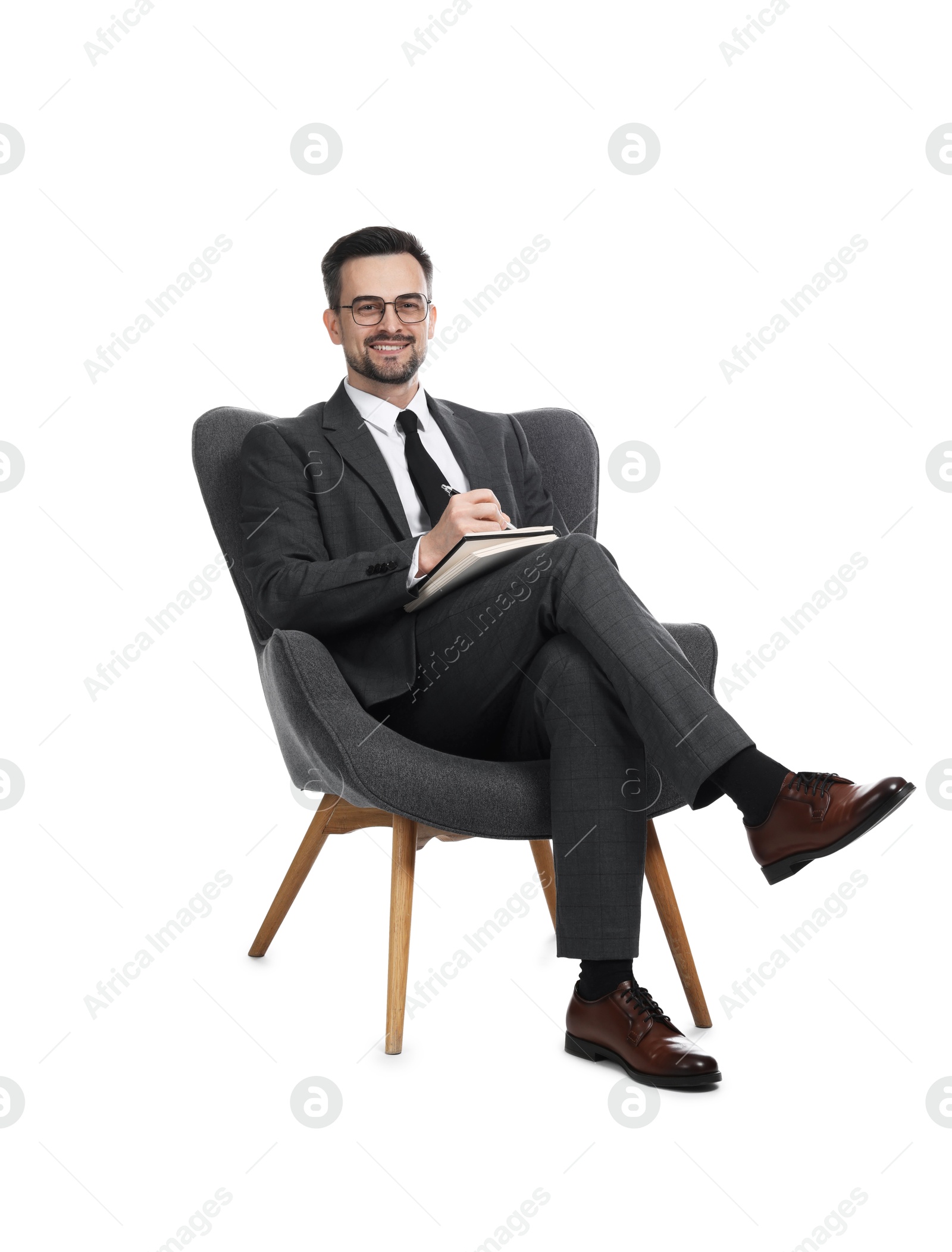 Professional psychologist with notebook in armchair on white background Photo of Professional psychologist with notebook in armchair on white background