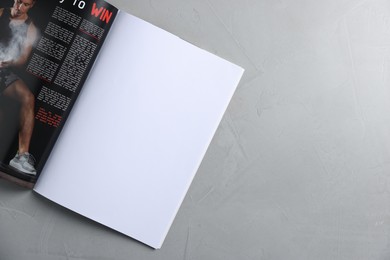 Photo of Open magazine on light grey table, top view. Mockup for design