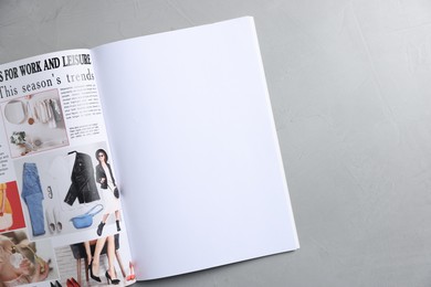 Photo of Open magazine on light grey table, top view. Mockup for design