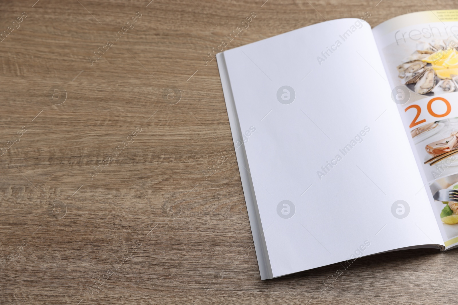 Open magazine on wooden table. Mockup for design Photo of Open magazine on wooden table. Mockup for design