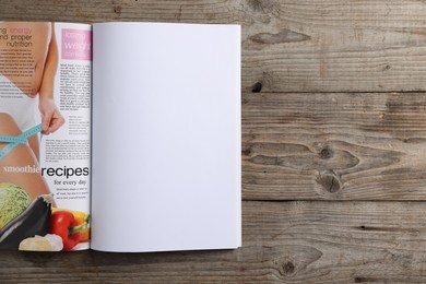 Photo of Open magazine on wooden table, top view. Mockup for design