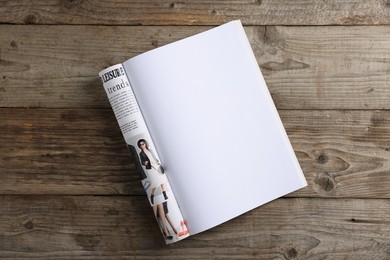 Photo of Open magazine on wooden table, top view. Mockup for design