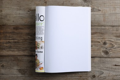 Photo of Open magazine on wooden table, top view. Mockup for design