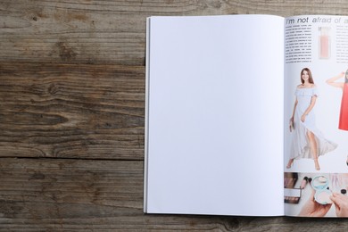 Photo of Open magazine on wooden table, top view. Mockup for design
