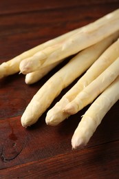 Photo of Many raw asparagus spears on wooden table, closeup