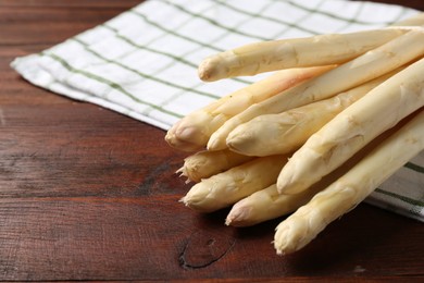 Photo of Raw asparagus spears on wooden table, closeup. Space for text