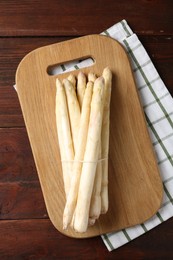 Photo of Raw asparagus spears on wooden table, top view