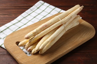 Photo of Raw asparagus spears on wooden table, closeup