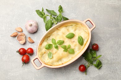 Photo of Tasty vegetarian lasagna and ingredients on grey table, flat lay