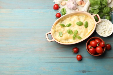Photo of Tasty vegetarian lasagna and ingredients on light blue wooden table, flat lay. Space for text