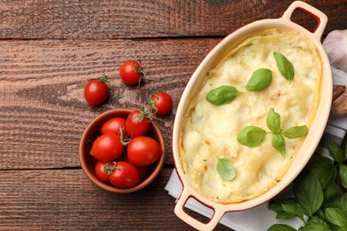 Photo of Tasty vegetarian lasagna and ingredients on wooden table, flat lay