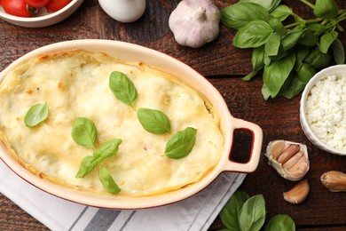 Photo of Tasty vegetarian lasagna and ingredients on wooden table, flat lay