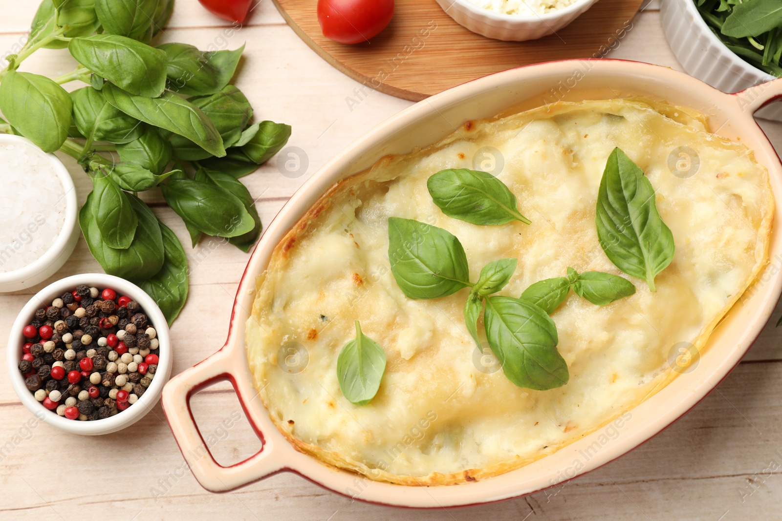 Photo of Tasty vegetarian lasagna and ingredients on wooden table, flat lay