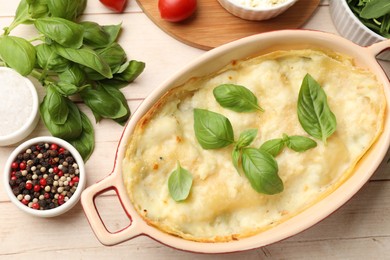 Photo of Tasty vegetarian lasagna and ingredients on wooden table, flat lay