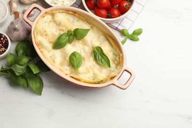 Photo of Tasty vegetarian lasagna and ingredients on white marble table, flat lay. Space for text