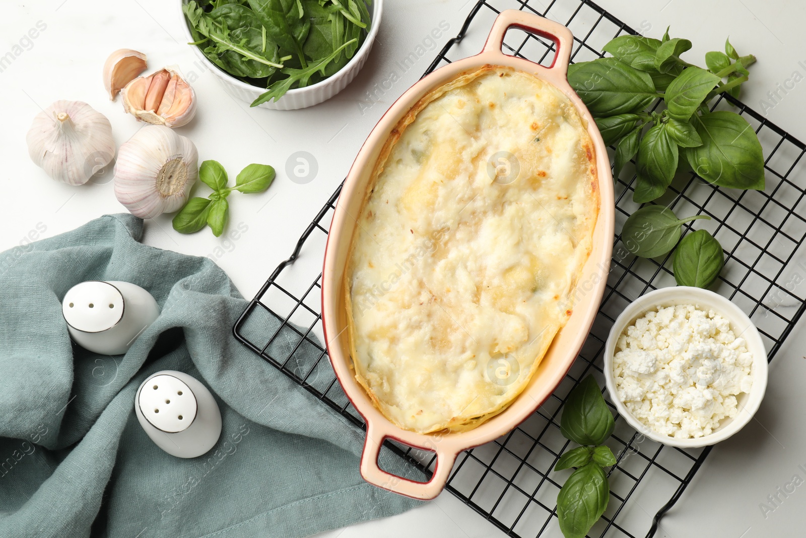 Photo of Tasty vegetarian lasagna and ingredients on white marble table, flat lay